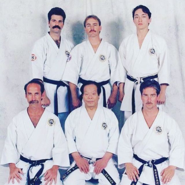 Archival photograph of a Japanese karate master seated with senior black-belt students
